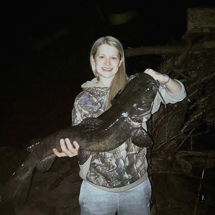 Dr. Taylor Runkle holding a large catfish — fishing is a longtime hobby of hers.